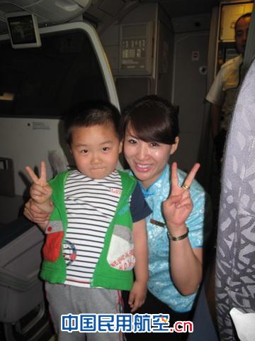 同航班乘务员工与参加儿童节特色航班活动的儿童合影 陪妈妈一起飞:东航“世园妈妈”的欢乐六一