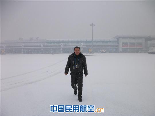 图4:除雪车司机隋福广踏雪而来进行机前勘查 蛇年春运的第一场雪