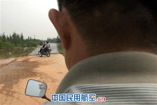 摩托车往前行驶没多远,又遇到被暴雨浸泡的一处低洼路段。 海南持续降雨 赴海口美兰机场航向台走访考察