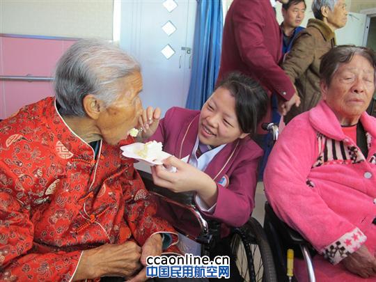 新疆地服员工正在给老人喂蛋糕 南航新疆地服:重阳节爱心慰问老人